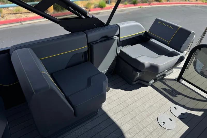 Slide: The Image of Interior seating of 2025 Manitou EXPLORE 24 boat with modern design and gray upholstery. - 16