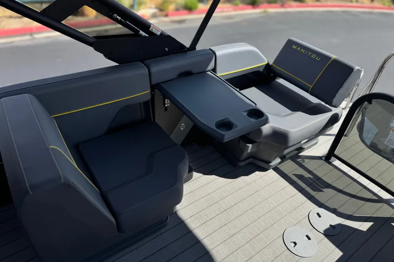Slide: The Image of Luxurious seating area on 2025 Manitou EXPLORE 24 boat with table and cup holders. - 17