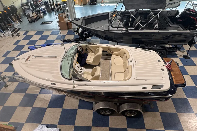 Slide: The Image of 2005 Chris Craft Speedster boat displayed indoors on a trailer. - 14