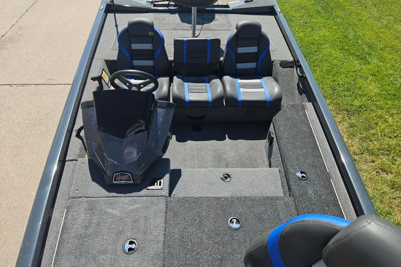 Slide: The Image of 2023 Ranger RT178 boat interior with gray and blue seating, steering console, and carpeted flooring. - 4
