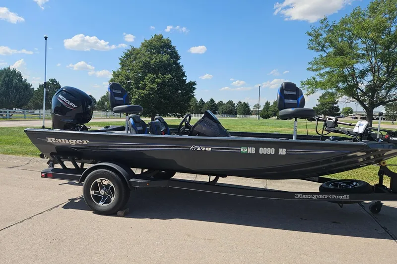 Slide: The Image of 2023 Ranger RT178 boat on trailer, parked outdoors under a clear blue sky. - 5
