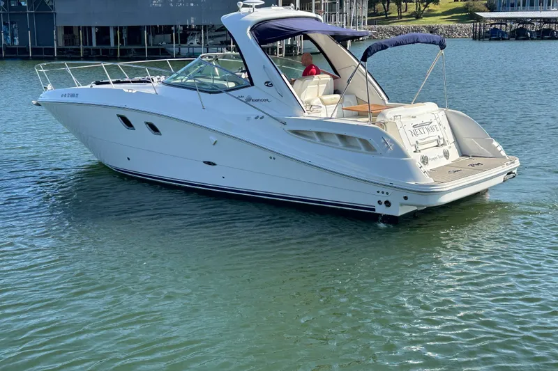 Slide: The Image of 2008 Sea Ray Sundancer 330 yacht on calm water, featuring sleek design and spacious deck. - 2