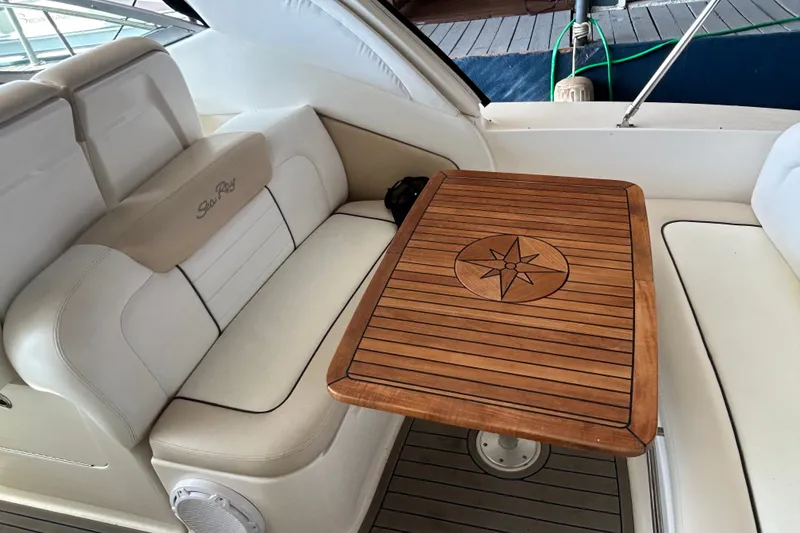 Slide: The Image of 2008 Sea Ray Sundancer 330 interior with elegant seating and wooden table featuring compass design. - 27