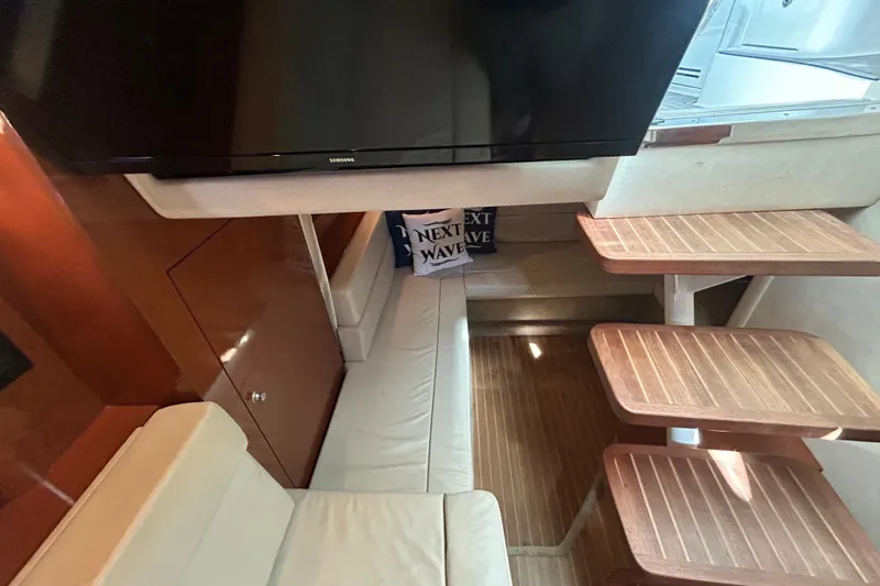 Slide: The Image of Interior of 2008 Sea Ray Sundancer 330 with TV, seating, and wooden steps. - 12