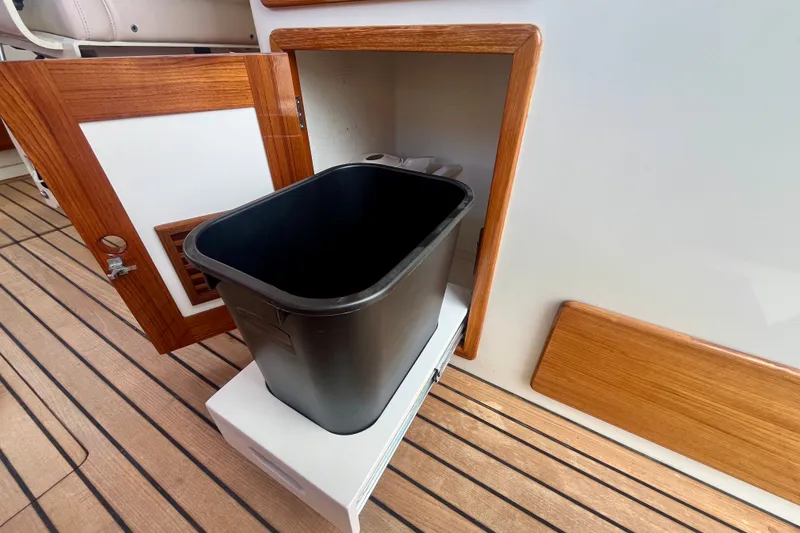Slide: The Image of Open wooden cabinet with black trash bin on Little Harbor Whisper Jet 38 Prop, 2001 model. - 33