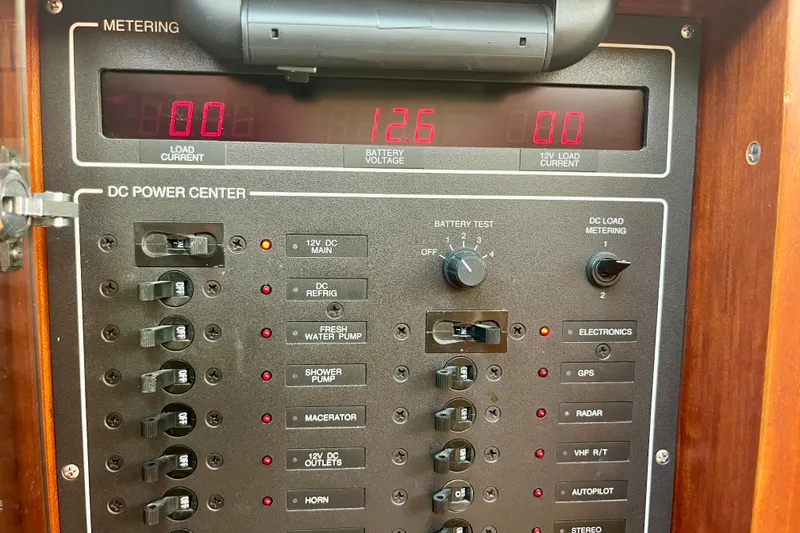 Slide: The Image of Control panel of a 2001 Little Harbor Whisper Jet 38 Prop boat, showing battery voltage and switches. - 36