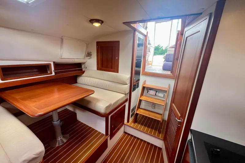 Slide: The Image of Interior of 2001 Little Harbor Whisper Jet 38 Prop with wooden table and seating. - 24