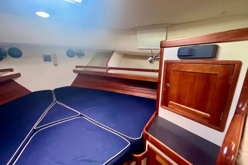Slide: The Image of Interior cabin of 2001 Little Harbor Whisper Jet 38 Prop with blue cushions and wooden cabinetry. - 19