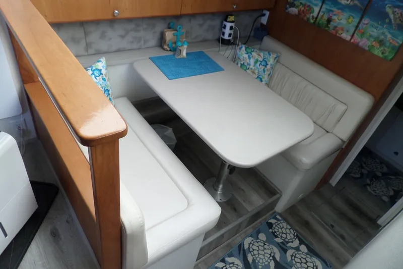 Slide: The Image of 1994 Silverton 34 Aft Cabin Motor Yacht interior with cozy dining area and nautical decor. - 32