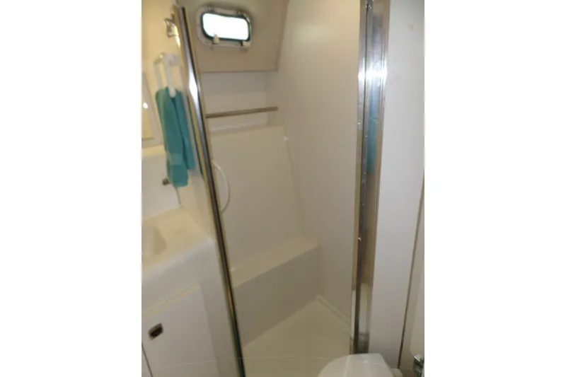 Slide: The Image of Bathroom interior of 1994 Silverton 34 Aft Cabin Motor Yacht, featuring shower and porthole. - 45