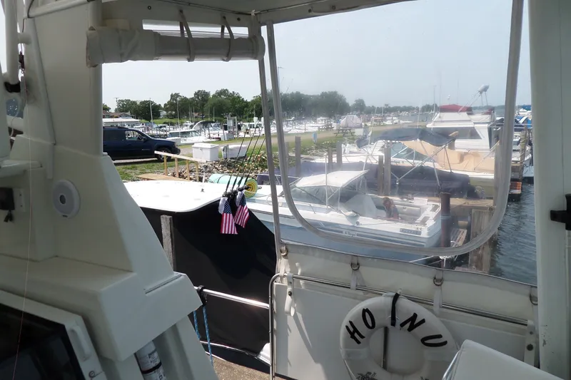 Slide: The Image of 1994 Silverton 34 Aft Cabin Motor Yacht docked at marina with boats and greenery. - 28