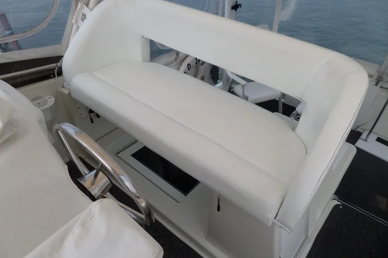 Slide: The Image of White helm seat on 1994 Silverton 34 Aft Cabin Motor Yacht, featuring a sleek steering wheel. - 12