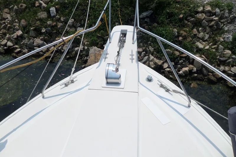 Slide: The Image of Bow view of 1994 Silverton 34 Aft Cabin Motor Yacht near rocky shoreline. - 68