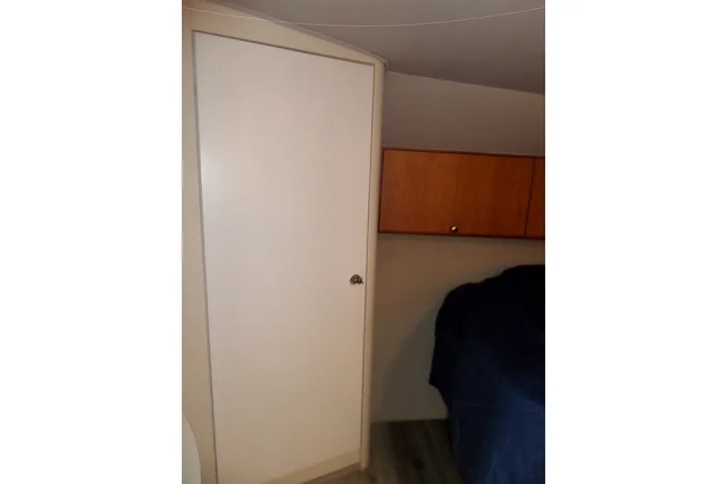 Slide: The Image of Interior of 1994 Silverton 34 Aft Cabin Motor Yacht showing closet and wooden cabinet. - 52