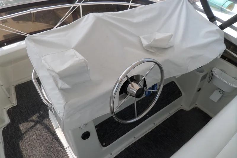 Slide: The Image of 1994 Silverton 34 Aft Cabin Motor Yacht helm with covered controls and steering wheel. - 13