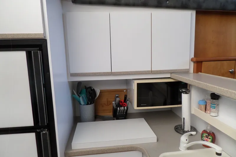 Slide: The Image of 1994 Silverton 34 Aft Cabin Motor Yacht kitchen with microwave, cabinets, and utensils. - 34