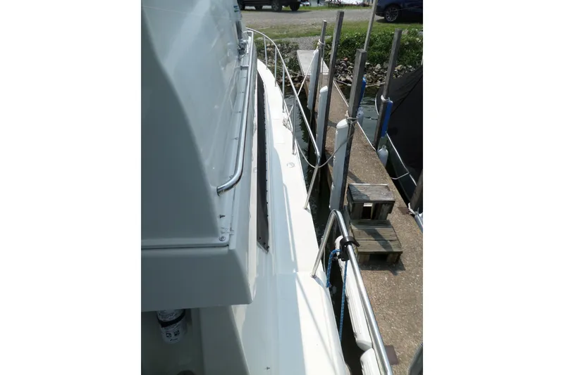 Slide: The Image of 1994 Silverton 34 Aft Cabin Motor Yacht docked, side view with railing and dock posts. - 29