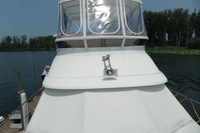 Slide: The Image of 1994 Silverton 34 Aft Cabin Motor Yacht docked on a serene lake. - 69