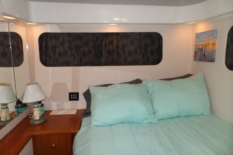Slide: The Image of Cozy bedroom in 1994 Silverton 34 Aft Cabin Motor Yacht with teal bedding. - 58