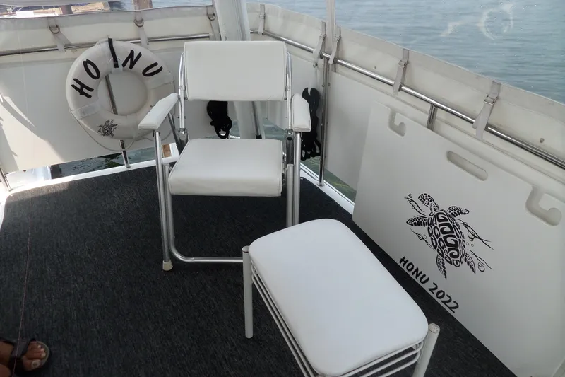Slide: The Image of 1994 Silverton 34 Aft Cabin Motor Yacht interior with white seating and "Honu 2022" decor. - 27