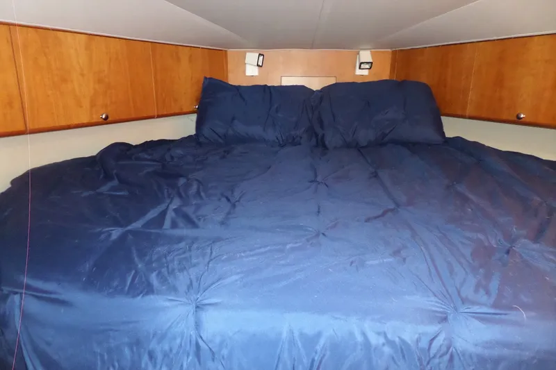 Slide: The Image of Cozy cabin bedroom in 1994 Silverton 34 Aft Cabin Motor Yacht with blue bedding. - 49