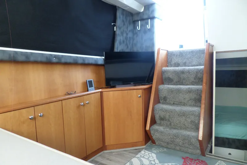 Slide: The Image of 1994 Silverton 34 Aft Cabin Motor Yacht interior with stairs, cabinets, and TV. - 41