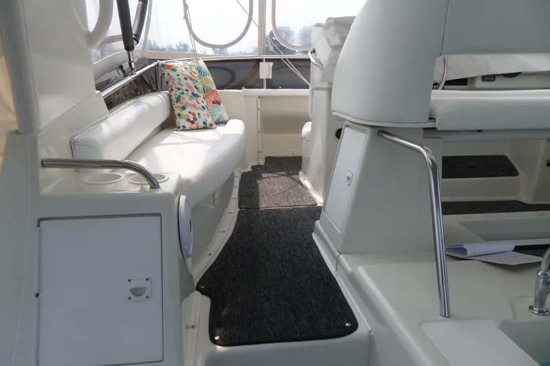 Slide: The Image of Interior of 1994 Silverton 34 Aft Cabin Motor Yacht with white seating and colorful pillow. - 16