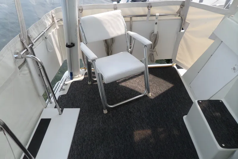 Slide: The Image of 1994 Silverton 34 Aft Cabin Motor Yacht deck with white chair and railing. - 25