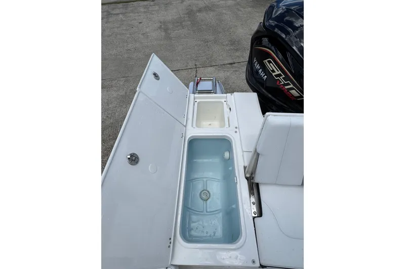 Slide: The Image of 2026 Robalo 226 Cayman boat with open storage compartments and Yamaha engine. - 17