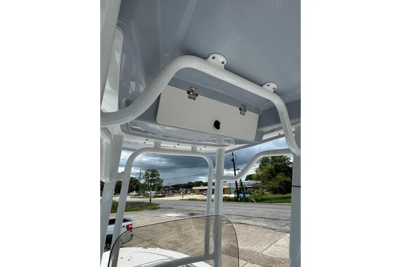 Slide: The Image of 2026 Robalo 226 Cayman boat T-top with storage compartment and scenic background. - 23