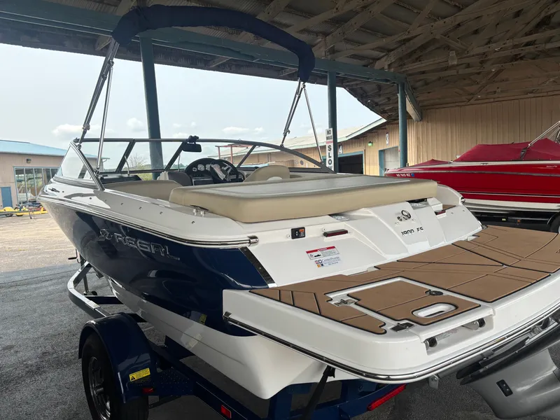 Slide: The Image of A 2017 Regal 1900 ES Bowrider is parked in a covered area. The boat features a blue and white finish. - 4