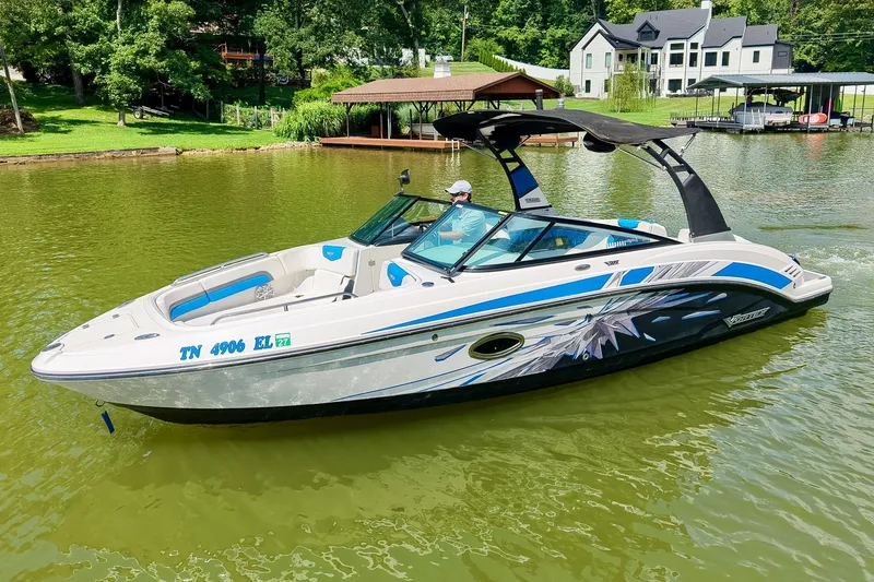 The Image of 2019 Chaparral 203 Vortex boat cruising on a scenic lake with lush greenery. - 0