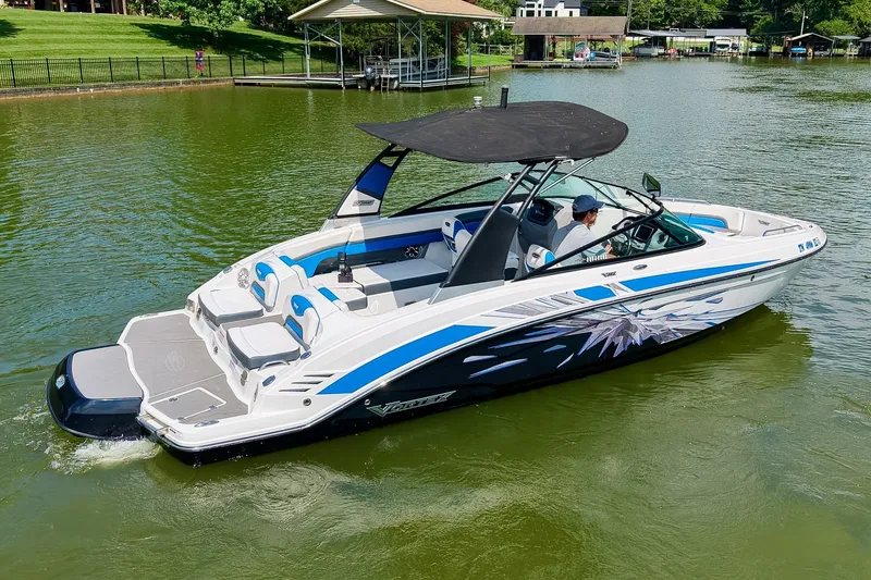 Slide: The Image of 2019 Chaparral 203 Vortex boat cruising on a serene lake with lush greenery. - 5