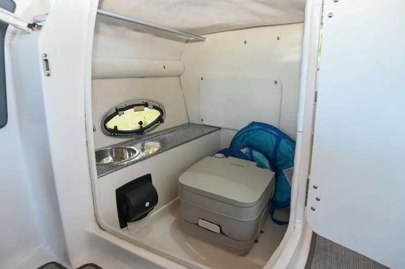Slide: The Image of 2019 Chaparral Vortex 2430 VRX boat interior with sink and portable toilet. - 33