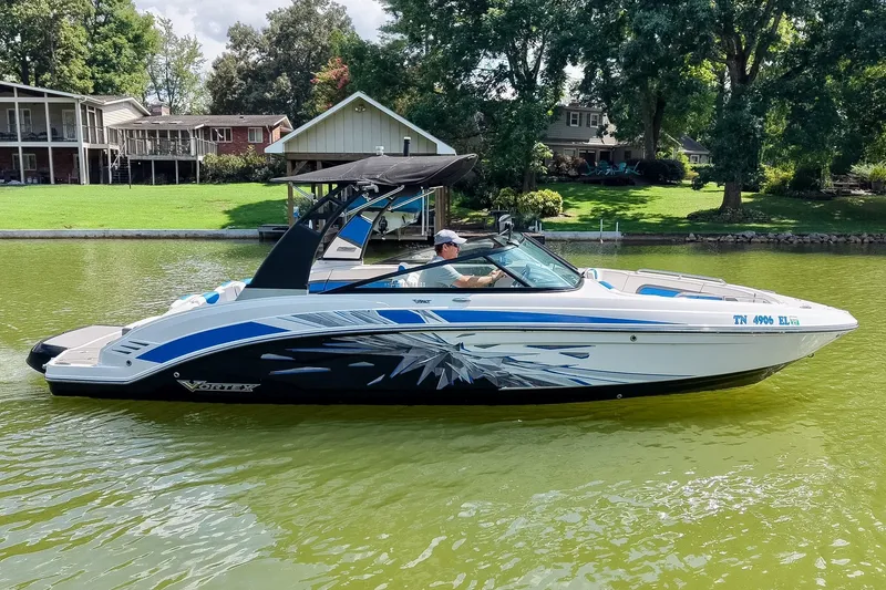 Slide: The Image of 2019 Chaparral 203 Vortex boat cruising on a scenic lake near waterfront homes. - 3