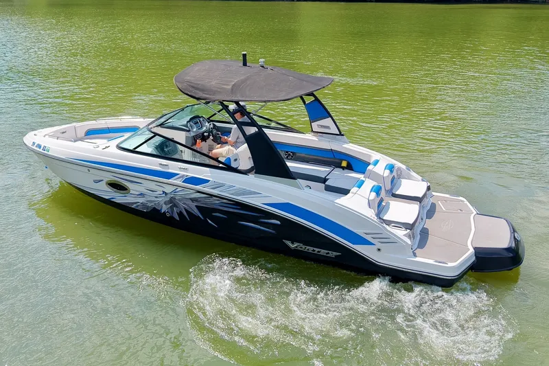 Slide: The Image of 2019 Chaparral 203 Vortex boat cruising on green water, featuring sleek design and canopy. - 7