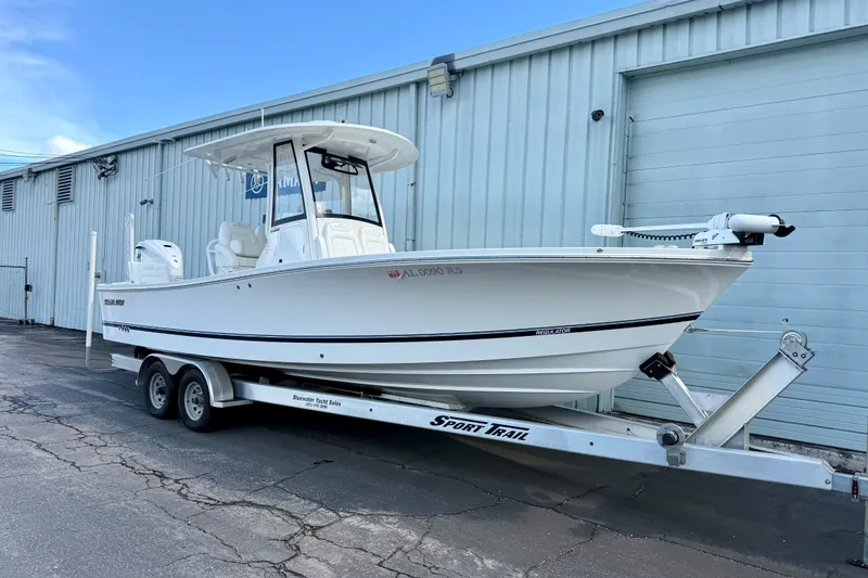 Slide: The Image of 2021 Regulator 26XO boat on trailer, parked outside a warehouse. - 1