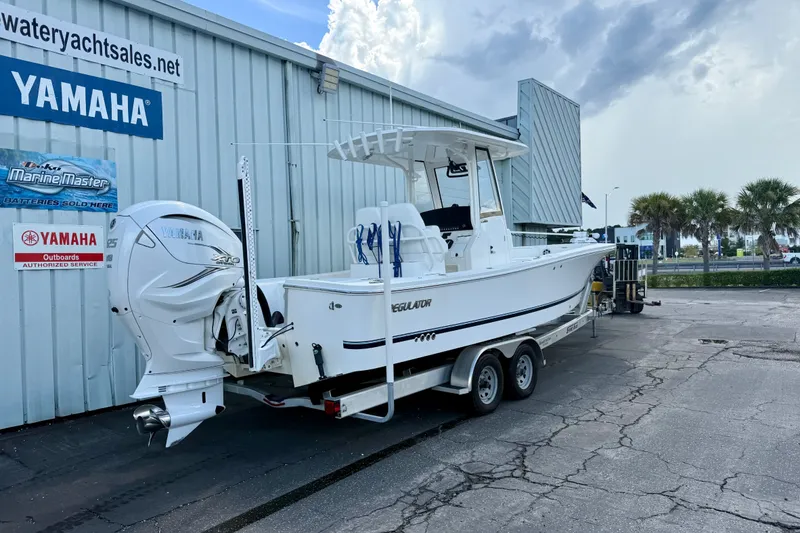 Slide: The Image of 2021 Regulator 26XO boat with Yamaha engine on trailer at dealership. - 2