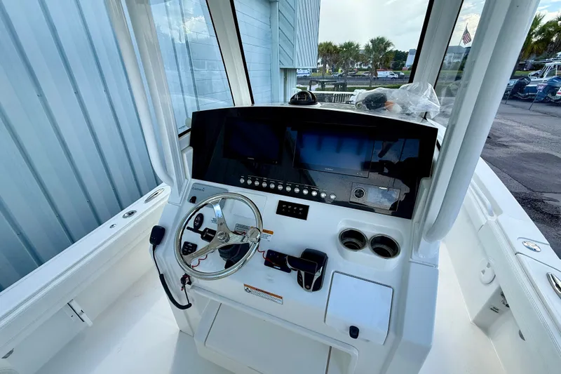 Slide: The Image of 2021 Regulator 26XO boat helm with steering wheel and control panel. - 8