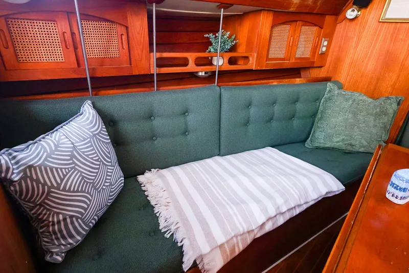 Slide: The Image of Cozy interior of 1990 Ericson 32.5 sailboat with green cushions and decorative pillows. - 33