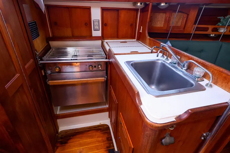 Slide: The Image of 1990 Ericson 32.5 yacht kitchen with stainless steel sink and stove, wooden cabinetry. - 27