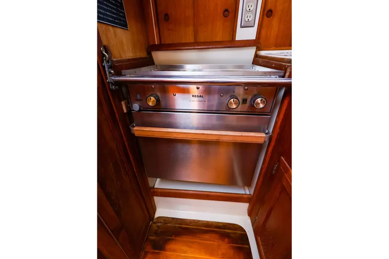 Slide: The Image of Stainless steel oven in 1990 Ericson 32.5 yacht galley, featuring wooden cabinetry. - 28
