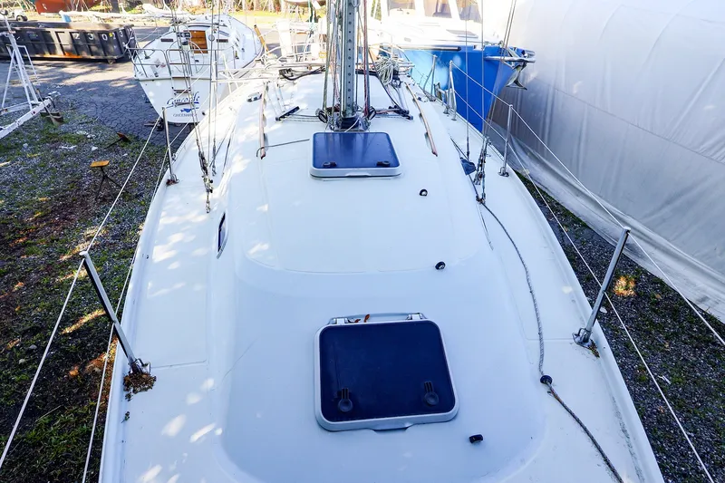 Slide: The Image of 1990 Ericson 32.5 sailboat deck view, featuring hatches and rigging. - 19