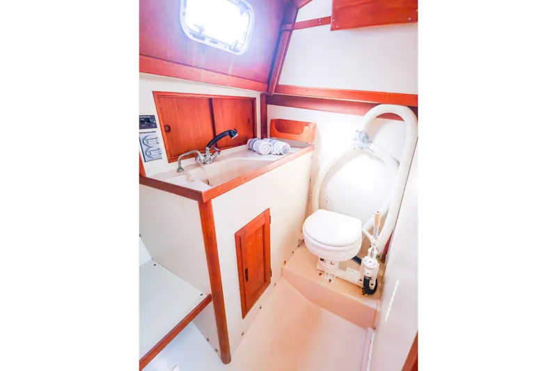 Slide: The Image of 1990 Ericson 32.5 yacht bathroom with sink, toilet, and wooden cabinetry. - 38