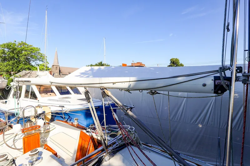 Slide: The Image of Ericson 32.5 sailboat from 1990 docked, featuring rigging and deck details under clear sky. - 21