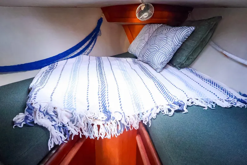 Slide: The Image of Cozy cabin interior of 1990 Ericson 32.5 sailboat with pillows and striped blanket. - 37