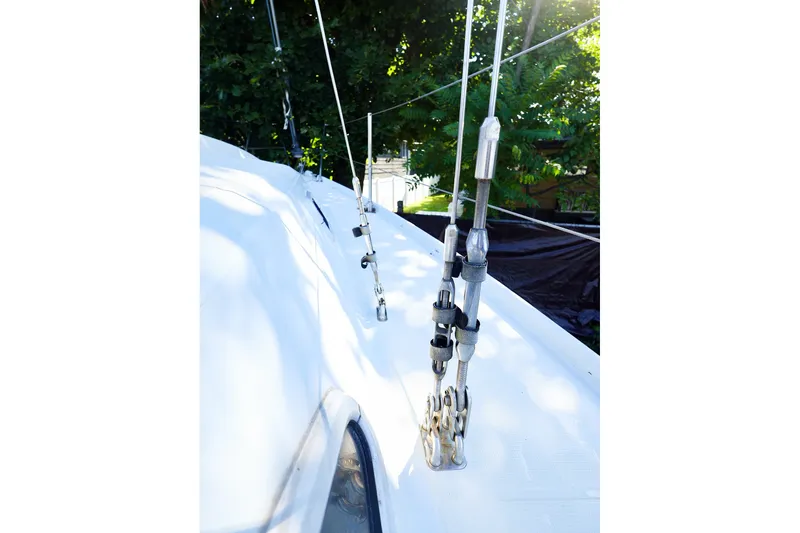Slide: The Image of Close-up of rigging on a 1990 Ericson 32.5 sailboat, with lush greenery in the background. - 16