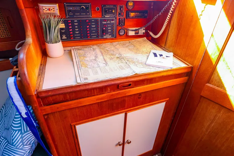 Slide: The Image of Navigation station on a 1990 Ericson 32.5 sailboat with maps and control panels. - 30