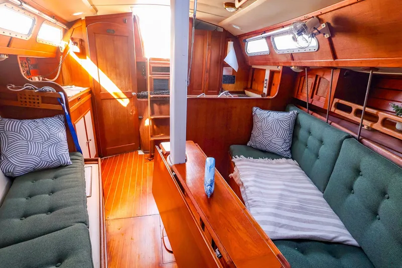 Slide: The Image of Cozy interior of a 1990 Ericson 32.5 sailboat with green cushions and wooden finishes. - 36