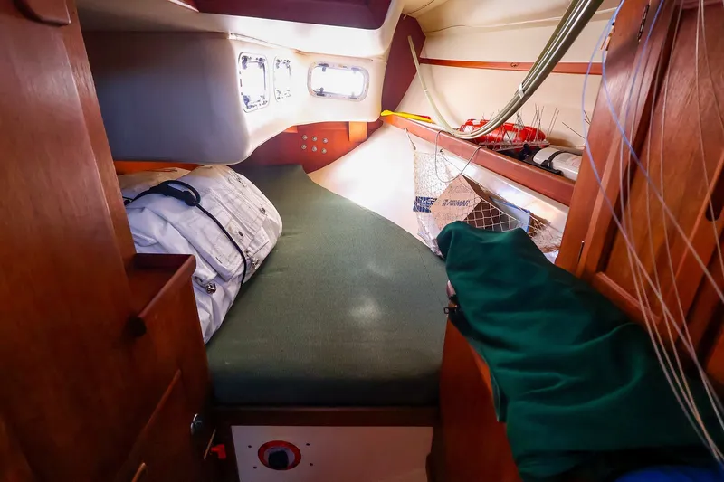 Slide: The Image of Cozy cabin interior of a 1990 Ericson 32.5 sailboat with green bedding and wooden accents. - 39